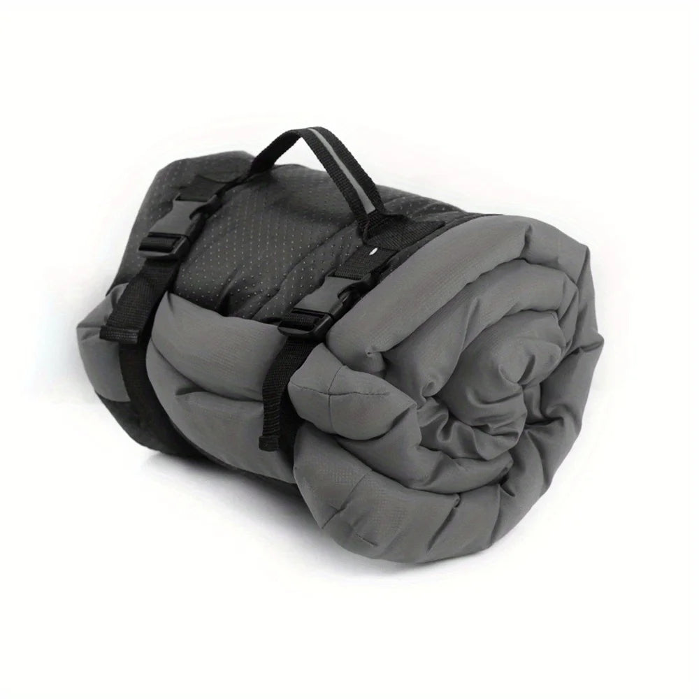 Gray sleeping bag rolled up with black straps on a white background