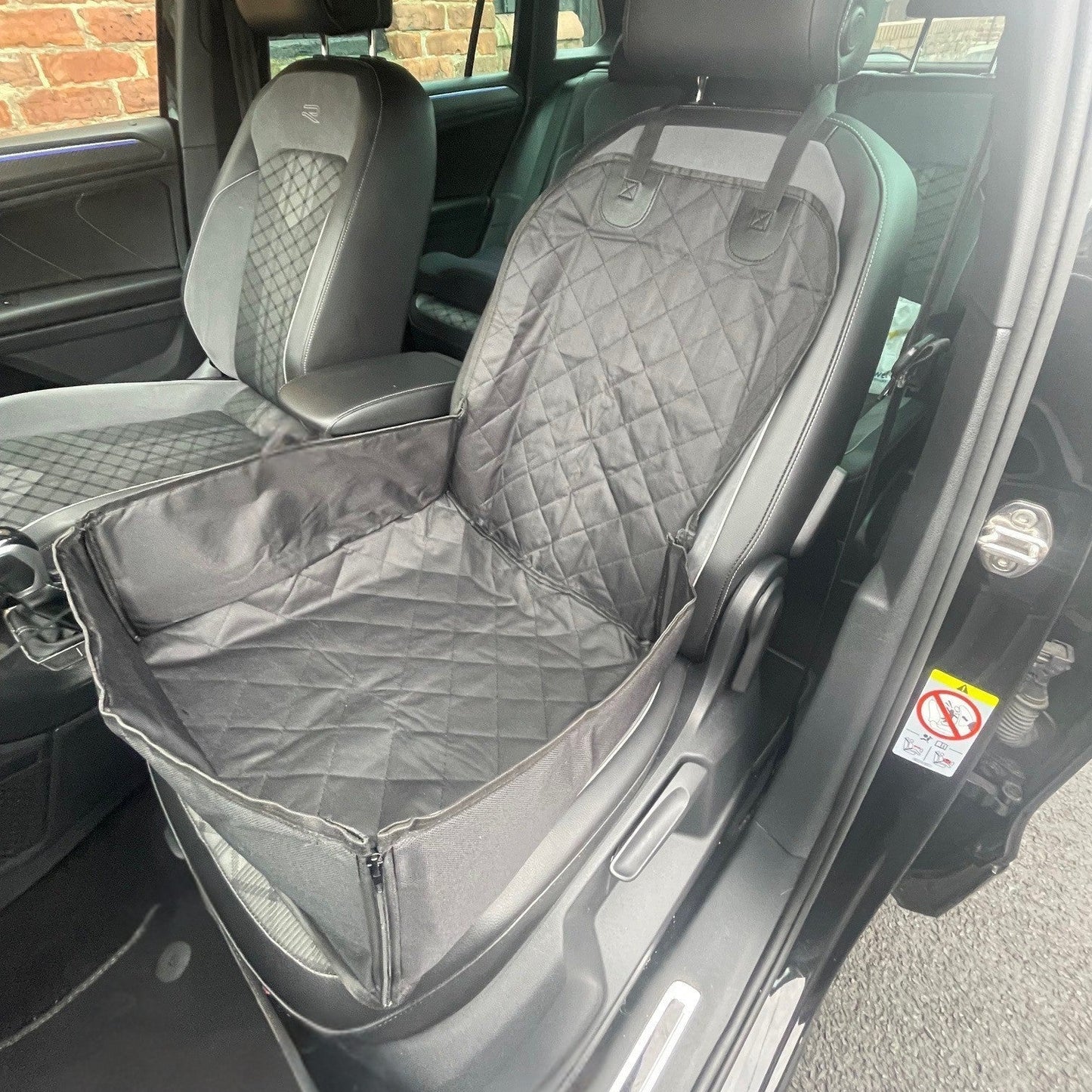 Car interior with a gray seat cover on the driver's side.
