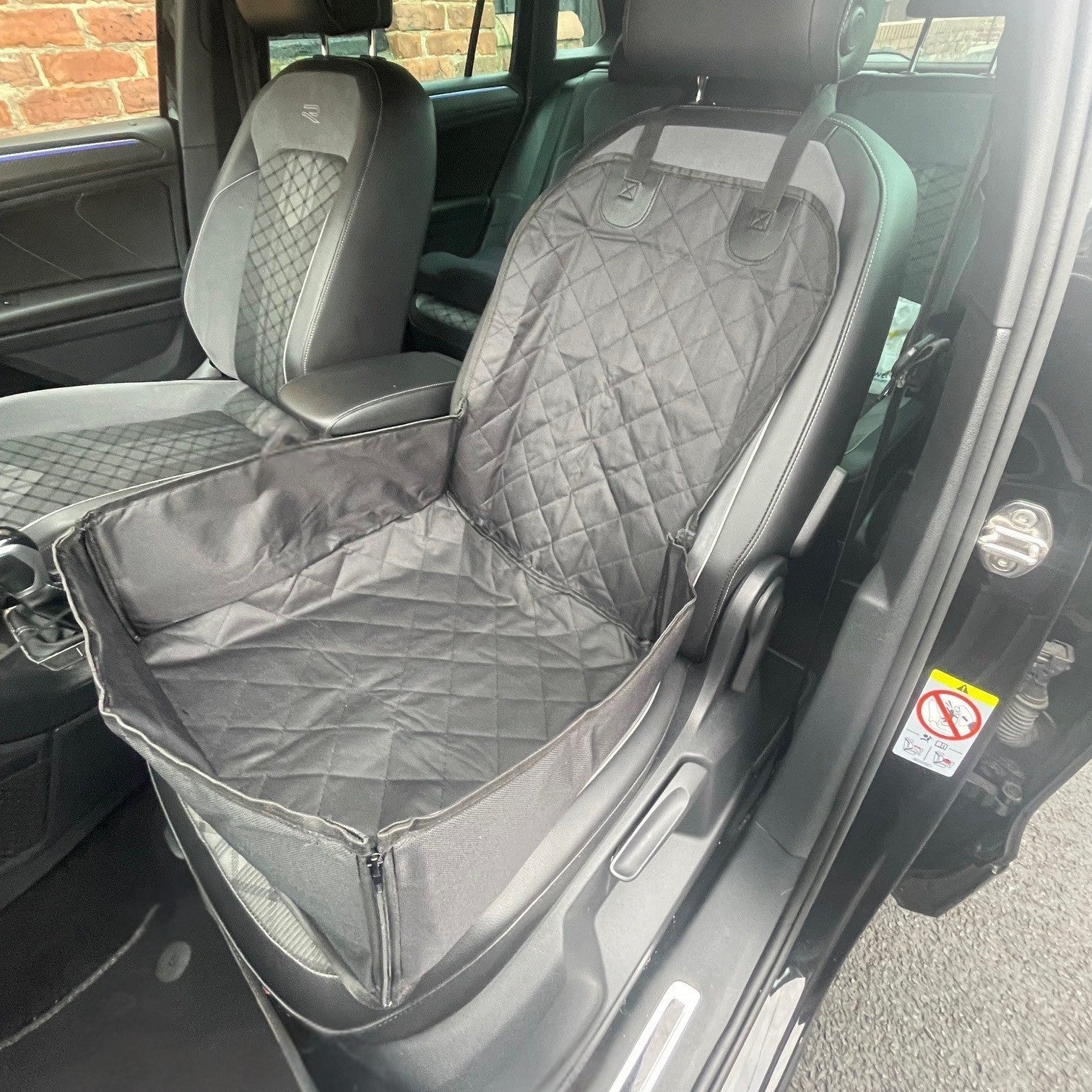 Car interior with a gray seat cover on the driver's side.