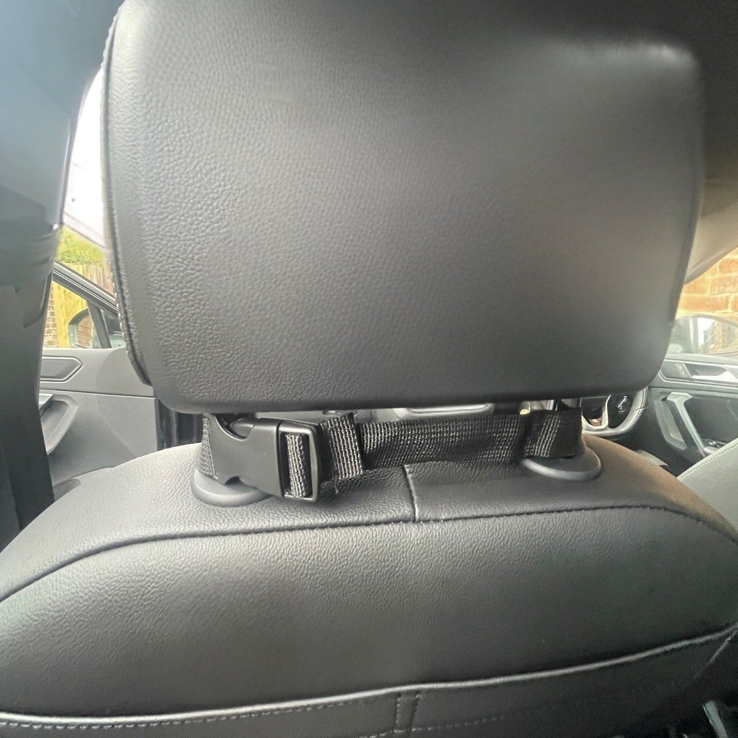 Car headrest with a strap in a vehicle interior