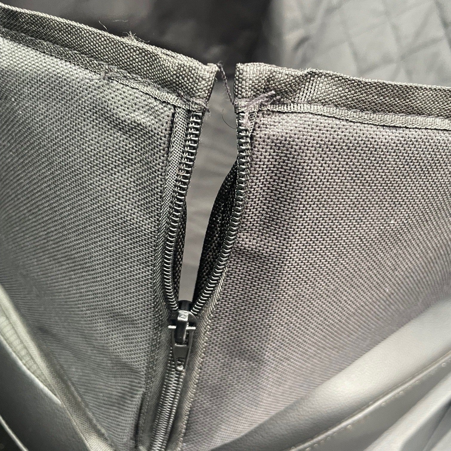 Close-up of a gray bag with a zipper
